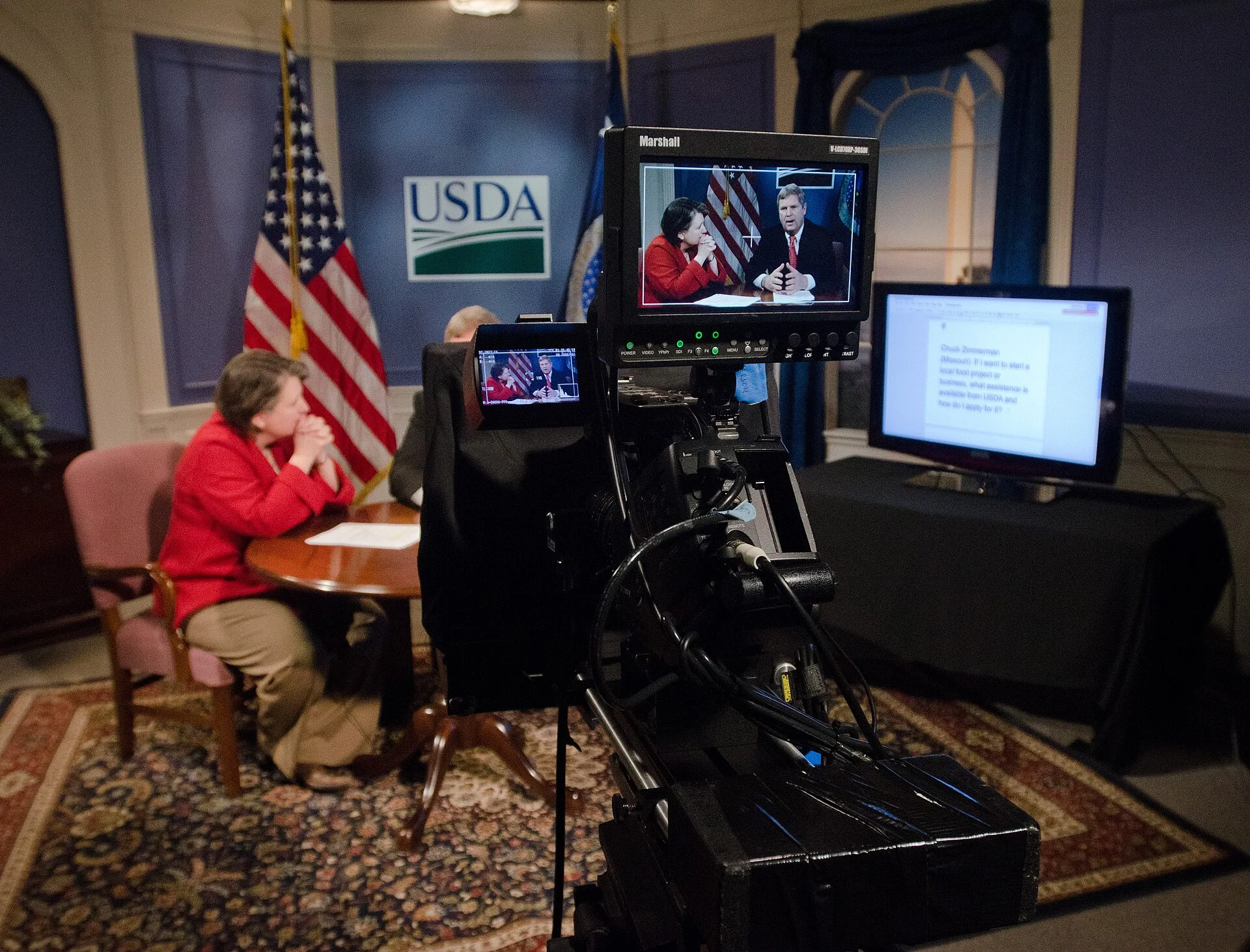 Seen though video camera monitors, Agriculture Secretary Tom Vilsack and Agriculture Deputy Secretary Kathleen Merrigan received a question via twitter message while in the USDA TV studio, during the unveiling of the Know Your Farmer, Know Your Food (KYF) Compass, an interactive web-based document a